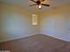 A cozy bedroom features a ceiling fan and a window for natural light and neutral carpet at 8776 W Peppertree Ln, Glendale, AZ 85305