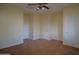 This bedroom features neutral walls, carpeted flooring, ceiling fan, and white doors at 8776 W Peppertree Ln, Glendale, AZ 85305