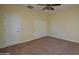 Bedroom with plush carpet, ceiling fan, and multiple closets at 8776 W Peppertree Ln, Glendale, AZ 85305