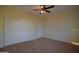 A cozy bedroom features a ceiling fan and a double door closet and neutral carpet at 8776 W Peppertree Ln, Glendale, AZ 85305