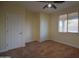 This bedroom features neutral walls, ceiling fan, carpeted flooring, and a window at 8776 W Peppertree Ln, Glendale, AZ 85305