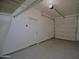 An attached two-car garage with epoxy floor, overhead lighting, and white walls at 8776 W Peppertree Ln, Glendale, AZ 85305