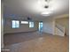 Spacious, bright living room features tile, carpet, stairs, and large windows for plenty of natural light at 8776 W Peppertree Ln, Glendale, AZ 85305