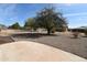 Backyard featuring gravel landscaping, a mature shade tree and views of the surrounding neighborhood at 9431 W Timberline Dr, Sun City, AZ 85351