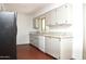 Kitchen featuring white cabinets and appliances, light countertop and wood look floors at 9431 W Timberline Dr, Sun City, AZ 85351