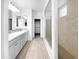 Bathroom featuring double sinks, decorative mirrors, and a large glass enclosed shower at 10064 E Tamery Ave, Mesa, AZ 85212