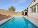 Backyard swimming pool surrounded by a privacy wall, artificial turf and desert landscaping at 10064 E Tamery Ave, Mesa, AZ 85212