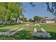 Picturesque view of community recreational area with manicured lawn and horseshoe pits under mature trees at 10119 N 96Th Ave # B, Peoria, AZ 85345