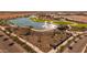 Aerial view of a scenic community lake featuring fountains, lush green spaces, and walking paths at 10233 S Bickwell Trl, Apache Junction, AZ 85120