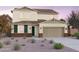 Charming two-story home boasts a neutral color palette, complemented by a two-car garage and desert landscaping at 10233 S Bickwell Trl, Apache Junction, AZ 85120