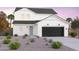 Charming new construction home featuring a black garage door, white paint, and desert landscaping at 10255 S Bickwell Trl, Apache Junction, AZ 85120