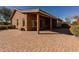 Expansive stone paver patio, ideal for gatherings, complemented by a covered area and desert landscaping at 11258 E Ocaso Ave, Mesa, AZ 85212