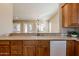 Granite countertop bar overlooking an airy living room and a modern, well-lit kitchen at 11258 E Ocaso Ave, Mesa, AZ 85212