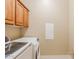 Bright laundry room features modern Samsung washer and dryer and extra storage in the upper cabinets at 11258 E Ocaso Ave, Mesa, AZ 85212