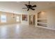 Spacious living room with tile floors, neutral walls, a ceiling fan, and built-in shelves at 11258 E Ocaso Ave, Mesa, AZ 85212