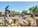 Grand entrance with statue, lush landscaping, and a gated entry for secure community access at 11500 E Cochise Dr # 1090, Scottsdale, AZ 85259