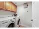 Well-lit laundry room with modern washer and dryer units and overhead storage at 11500 E Cochise Dr # 1090, Scottsdale, AZ 85259