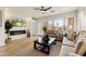 Cozy living room with a fireplace, comfortable sofas, a ceiling fan, and natural light streaming through the windows at 11500 E Cochise Dr # 1090, Scottsdale, AZ 85259