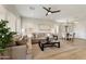 Spacious living room with tan sofa set, ceiling fan and an open view into the dining area and kitchen at 11500 E Cochise Dr # 1090, Scottsdale, AZ 85259