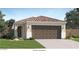 Charming single-story home featuring a tile roof, arched entry, two-car garage, and well-manicured lawn at 11942 E Primrose Ln, Florence, AZ 85132