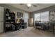 Bedroom with two desk areas, ceiling fan, carpeted floors, and a large window providing natural light at 12426 W Cougar Dr, Sun City West, AZ 85375