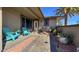 Charming front porch with stylish pavers, desert landscaping, and inviting turquoise Adirondack chairs at 12426 W Cougar Dr, Sun City West, AZ 85375