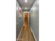 Hallway featuring hard wood floors, gray walls, white trim, and a doorway leading to another area at 12426 W Cougar Dr, Sun City West, AZ 85375