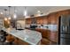 Well-lit kitchen features a large island with seating, stainless appliances, and mosaic backsplash at 12426 W Cougar Dr, Sun City West, AZ 85375