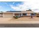 Charming single-story home with solar panels, blue trim, and low-maintenance desert landscaping at 12630 W Crystal Lake Dr, Sun City West, AZ 85375