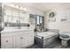 Bright bathroom featuring a soaking tub, dual sinks, and decorative artwork at 1438 S 30Th St, Mesa, AZ 85204