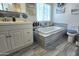 Bathroom featuring a soaking tub, vanity, and toilet, all accented by modern tile and fixtures at 1438 S 30Th St, Mesa, AZ 85204