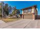 Inviting two-story home with a well-maintained lawn, a two-car garage, and mature trees under a bright sky at 1438 S 30Th St, Mesa, AZ 85204