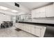 Bright kitchen with white cabinets, black countertops, and sleek appliances, leading to the dining area at 1438 S 30Th St, Mesa, AZ 85204