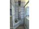 Modern shower featuring a large rainfall showerhead, body jets, stylish tile, and convenient in-shower shelving at 1438 S 30Th St, Mesa, AZ 85204