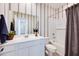 Bathroom featuring a single sink, white vanity, decorative mirror, and combined tub and shower with gray curtain at 14925 W Hackamore Dr, Surprise, AZ 85387