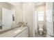 Bathroom featuring sleek vanity with a modern countertop, white cabinetry, and a separate toilet and shower area at 15022 W Smoketree Dr, Surprise, AZ 85387