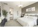 Comfortable bedroom with neutral tones, an accent wall, and ample natural light at 15022 W Smoketree Dr, Surprise, AZ 85387