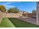 Private backyard featuring artificial grass, desert landscape, brick patio, lounge seating, and a block fence at 1576 E Jasper Ct # E, Gilbert, AZ 85296