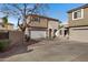 Tan two-story house features a multi-car driveway with a manicured front yard and mature tree at 1576 E Jasper Ct # E, Gilbert, AZ 85296