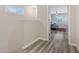 Hallway leading to bedroom with wood floors, white walls, and natural light from the window at 1576 E Jasper Ct # E, Gilbert, AZ 85296