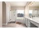 Bright bathroom featuring a glass-enclosed shower, soaking tub, and modern vanity with stylish lighting at 16428 N 59Th St, Scottsdale, AZ 85254