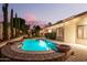 Inviting backyard pool with lush landscaping, ambient lighting, and a serene twilight sky at 16428 N 59Th St, Scottsdale, AZ 85254