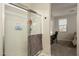 Bright bathroom with a glass-enclosed shower, and a partial view into an adjacent bedroom and desk area at 17618 W Paraiso Dr, Surprise, AZ 85387