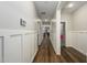 Bright hallway with paneled walls, showcasing durable laminate flooring and access to various rooms at 17618 W Paraiso Dr, Surprise, AZ 85387