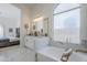 Elegant bathroom features a soaking tub and a vanity with dual sinks. A bedroom is visible in the background at 1881 E Erie St, Chandler, AZ 85225