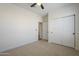 Bright bedroom featuring a ceiling fan, a closet with sliding doors, and neutral carpet at 1881 E Erie St, Chandler, AZ 85225