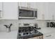 This kitchen showcases modern stainless steel appliances with white cabinets and granite countertops at 1881 E Erie St, Chandler, AZ 85225