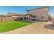 Spacious backyard featuring artificial grass, a covered patio, and a gravel area at 19242 W Madison St, Buckeye, AZ 85326