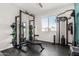 Spacious home gym featuring modern workout equipment, a mirror, and natural light from the window at 19242 W Madison St, Buckeye, AZ 85326