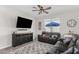 Comfortable living room featuring a ceiling fan, neutral tones, and large windows for natural light at 19242 W Madison St, Buckeye, AZ 85326